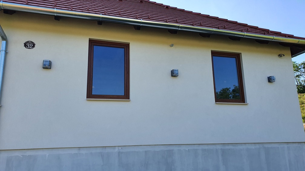 Családi ház homlokzatán felszerelt kültéri lámpák